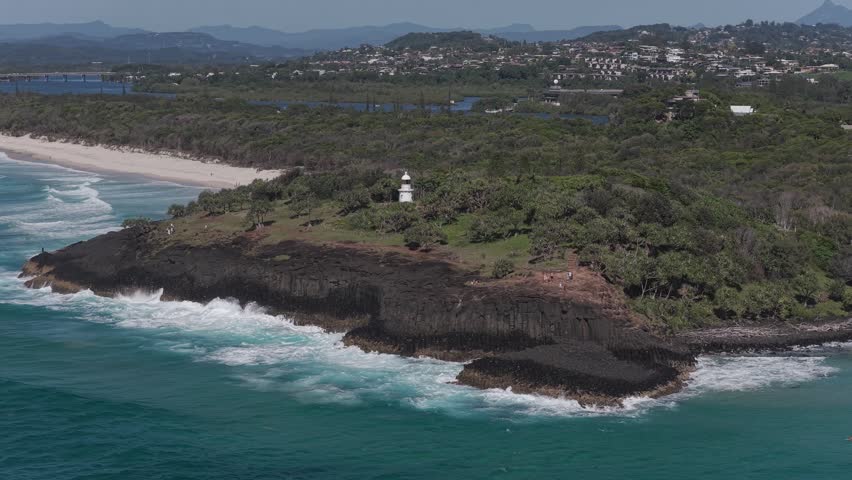 Fingal Head Lighthouse On Lush Green Headland With Tweed River In Background. NSW, Australia. aerial orbiting shot