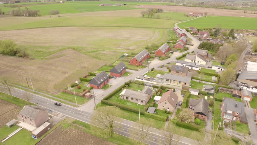 European Rural Village Alongside Road Bordered By Open Fields. Aerial Shot