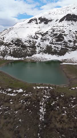 Mountain Lake Surrounded by Snow Covered Peaks and Rocky Landscape. 