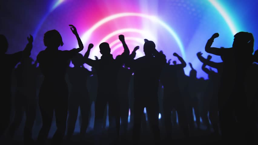 Concert crowd with raised hands enjoying the music and vibrant light show.