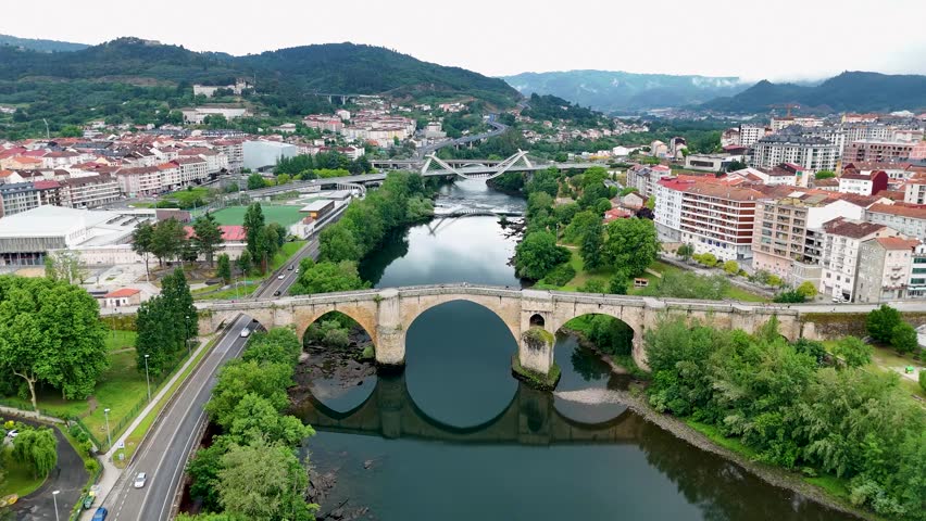 Majestic aerial view of the ponte vella, an ancient roman bridge crossing the minho river in ourense, galicia, with the city in the background
