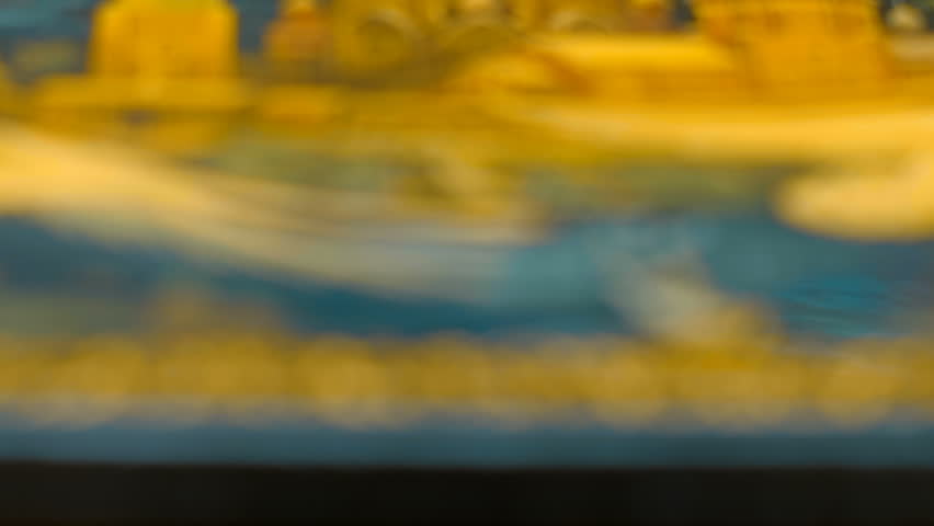 Beautiful shiny, sparkling golden jewelry with glare in gems in a beautiful colorful lacquered box. View through sparkling particles. Macro. Closeup. Shallow depth of field