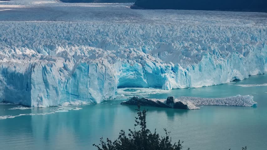 View over the vast Perito Moreno Glacier in Los Glaciares National Park, Argentina, showcasing striking white and blue ice formations meeting the waters of Lago Argentino in a dramatic landscape