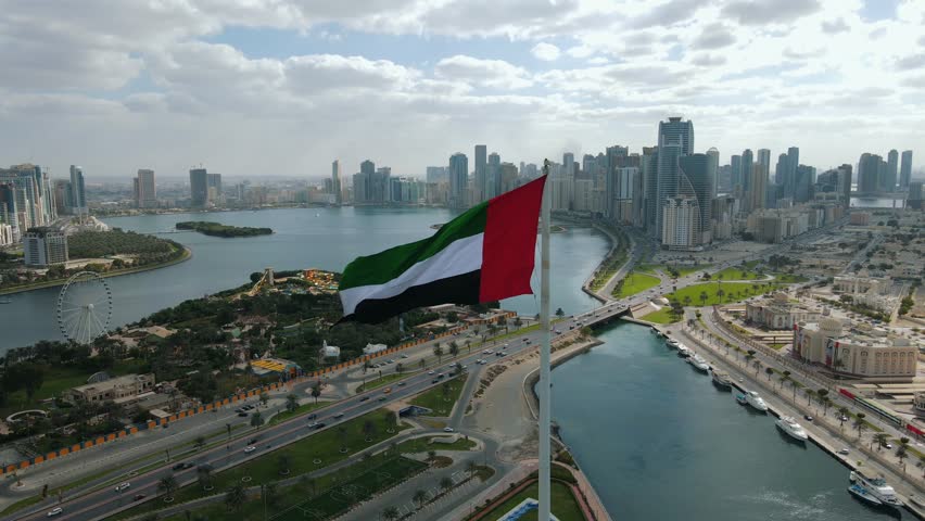 A giant UAE flag waves over the city of Sharjah, United Arab Emirates.