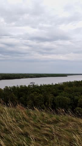 Cinematic wide shot of a boat on river under clouds