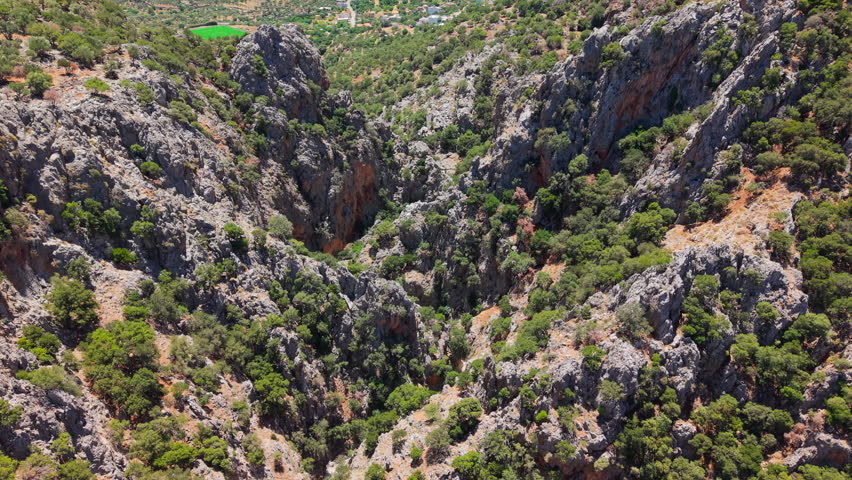 Looking down into a rugged mountain gorge with dramatic rock formations and forest