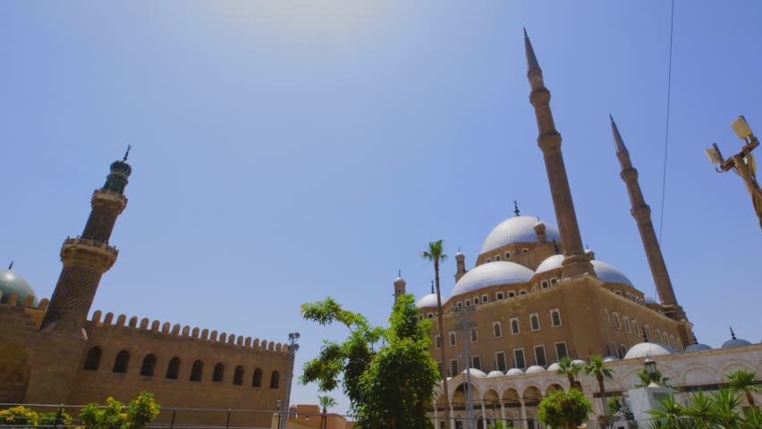 Horizontal camera movement revealing the grand mosque with domes and minarets in Cairo, Egypt, captured in cinematic slow motion 4K during travel.