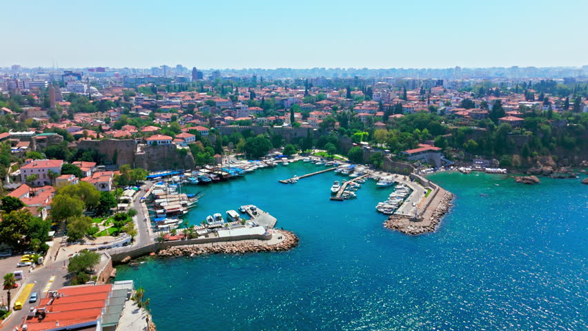 Drone view of Antalya, Turkey Kaleici Ancient City and Marina. Boats, harbor, rooftops and blue coastline show a historic destination.
