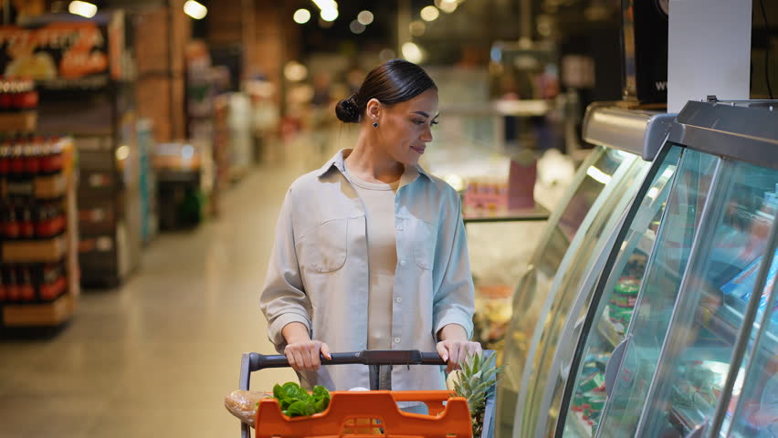 Woman choosing fresh fish in supermarket grocery section