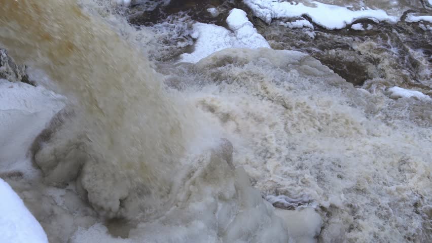 Motion clip of Keila waterfall, Estonia, flowing in winter with ice and snow formations