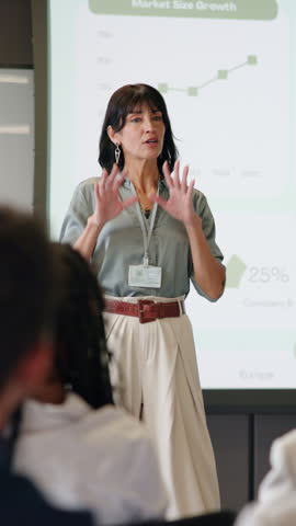 Woman, presentation and crowd at seminar with screen, graphs and discussion for market share growth. Person, speaker and whiteboard with insight, stats and charts with conference at finance agency