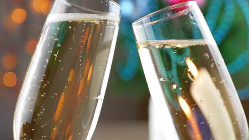 Lovely couple clinking glasses celebrating holding glasses with champagne, close-up hands New Year