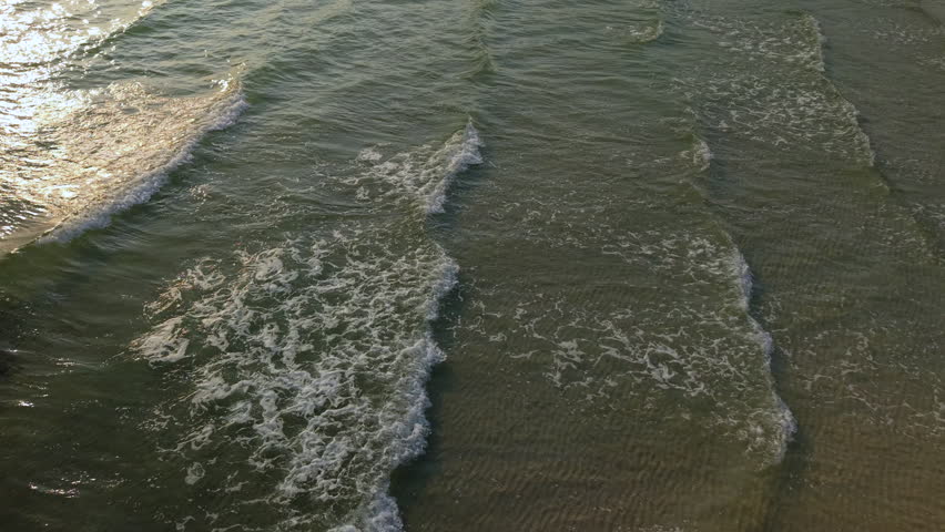 Gentle sea waves on the sandy beach shore.