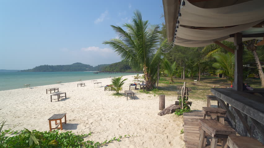 Beautiful tropical white sand beach with palm trees and clear blue water.