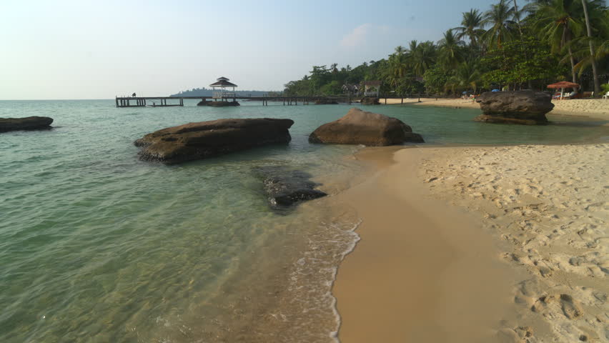 Tropical beach with white sand and coconut palm trees in Thailand.
