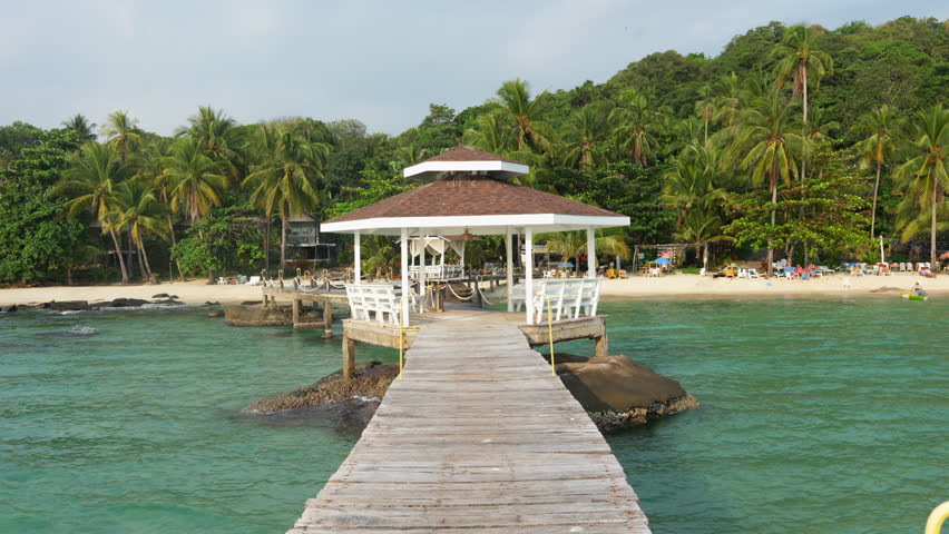 Tropical beach with white sand and coconut palm trees in Thailand.