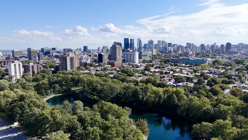 Aerial view of Montreal Parc La Fontaine with greenery and urban grid in the background. g.