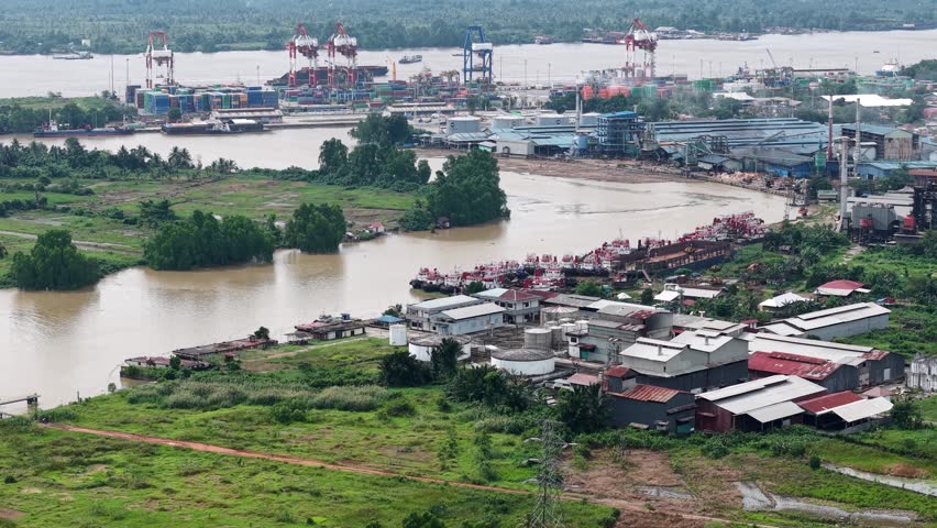 Tugboats lined up are parked on the edge of the Martapura River