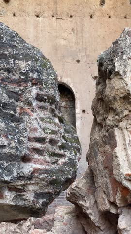 Panning shot between remnants of “Iglesia y Convento de Santa Clara” displaying an altar in the wall in Antigua Guatemala