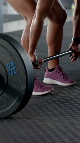 Vertical video: Lifter holding bar hand nudging collar deadlifting to train streaks showing motion. Weightlifting, strength, athlete, gym, fitness, training, vertical video