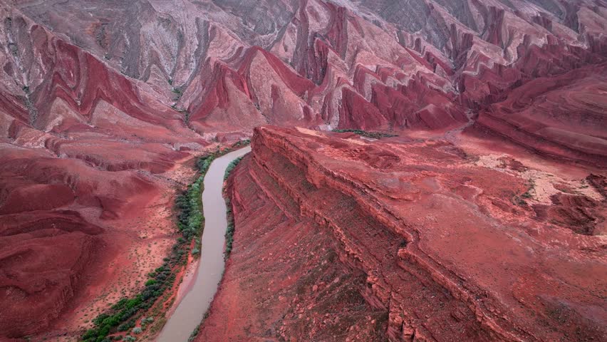 Aerial view of the Colorado River winding through dramatic red rock formations and steep cliffs Moab, Utah, United States.