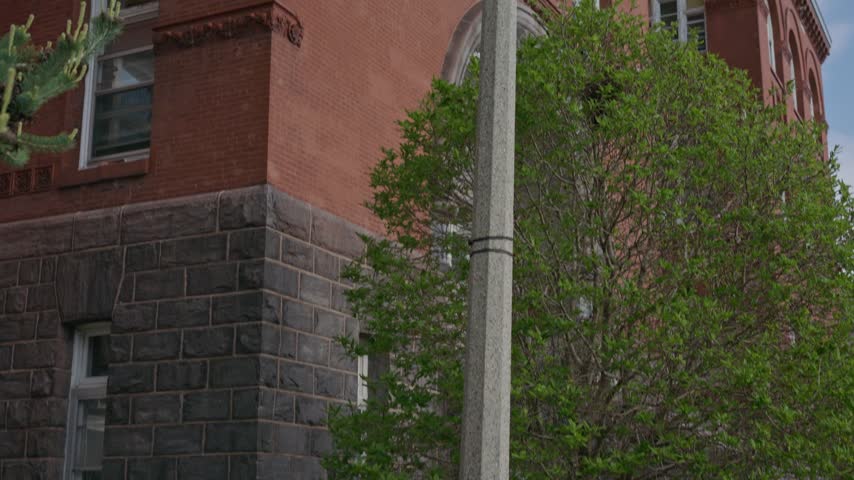 Cinematic gimbal tilt up shot of University of Wisconsin Science Hall with light post in foreground and smooth camera movement.