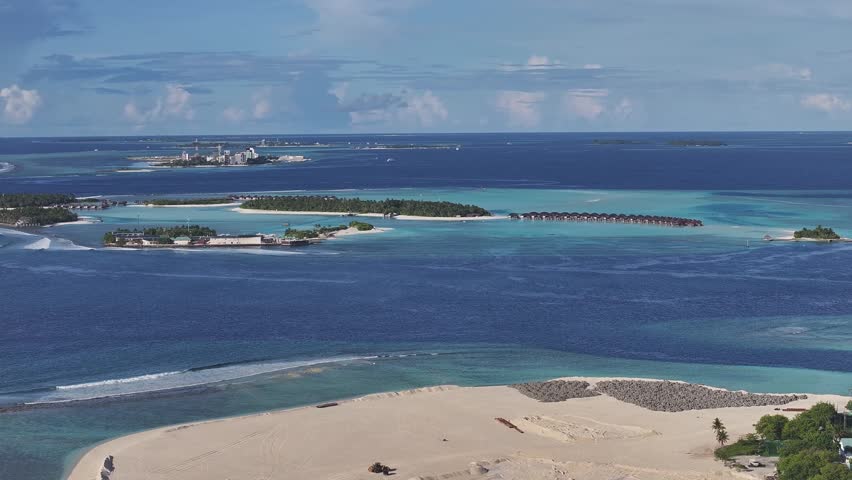 Aerial view of Gulhi island featuring turquoise lagoons, white sand beaches and overwater bungalows in Gulhi, Kaafu Atoll, Maldives.