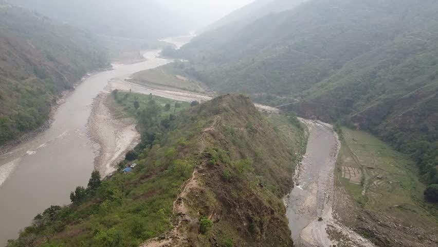 Aerial Drone View of Narrow Mountain Ridge Path Near Arun and Pikhuwa Rivers, 
Risky Hilltop Trail Overlooking River Valley in Remote Mountain Landscape,Remote Hiking Trail on Rocky Hill Beside Arun River Natural Landscape
