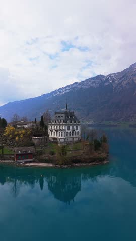 Vertical Droneshot of Iseltwald canton Bern in Switzerland during Spring. Iseltwald is surrounded by the lake Brienzersee and mountains.