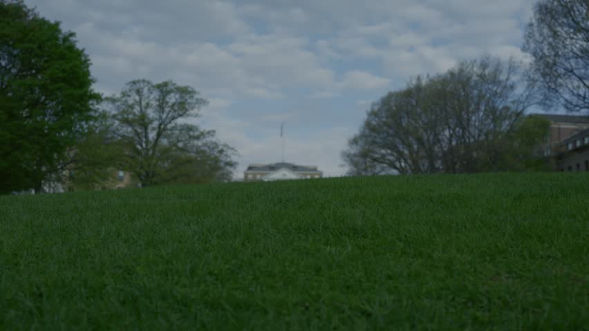Cinematic gimbal reveal shot moving up from grass to Bascom Hall at University of Wisconsin with smooth stabilized camera motion.