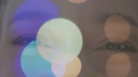 Female teen blinking in closeup as color bokeh drifting over eyes, causing eye reflections for tech. Iris, lashes, eyebrow, studio, lighting, lensflare, circles - Powered by Shutterstock - Get 15% off with code: PIKWIZARD15