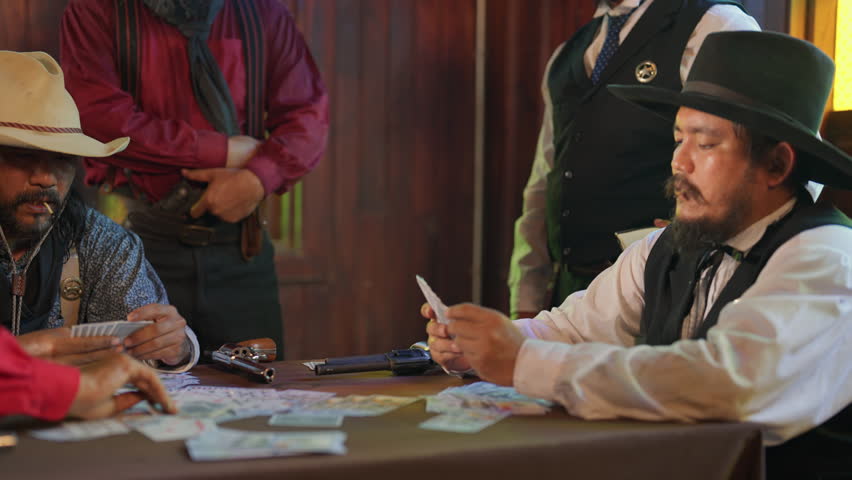 Group of cowboy men enjoy to play card in room together and someone is smoking also look like they concentrate to gambling.