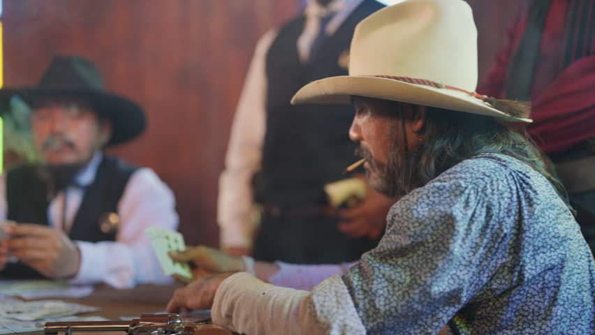 Group of cowboy smoke during play card as gambling and they look as gangster with old style and ready to battle together.