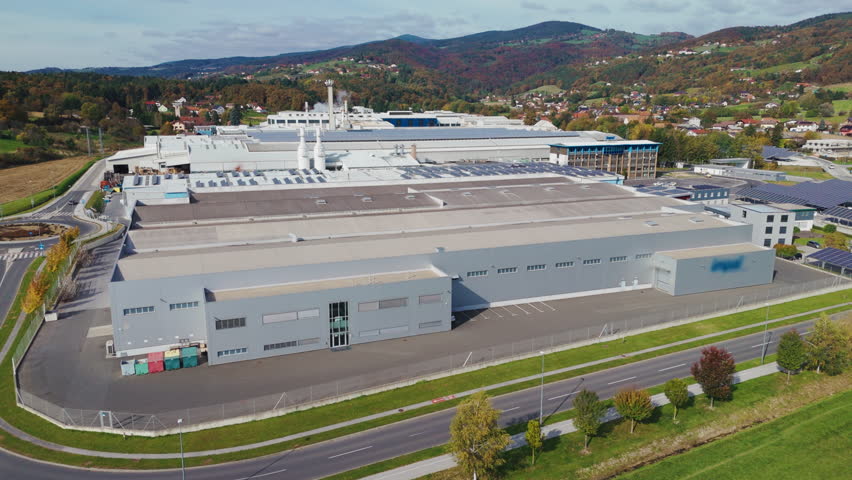 This aerial view displays a large aluminum factory surrounded by various industrial buildings and production facilities in the landscape.