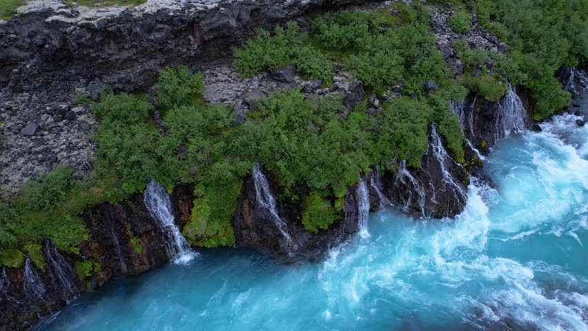 Aerial view of a stunning waterfall cascading over rocky terrain.