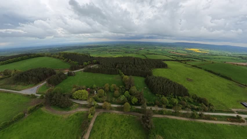 Stunning aerial view of green fields under a cloudy sky.