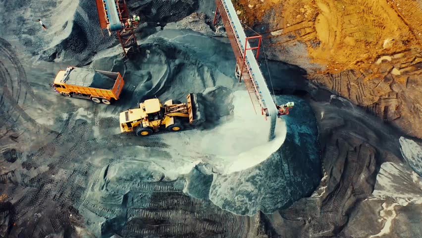 Aerial view of heavy machinery operating in a large mining excavation site