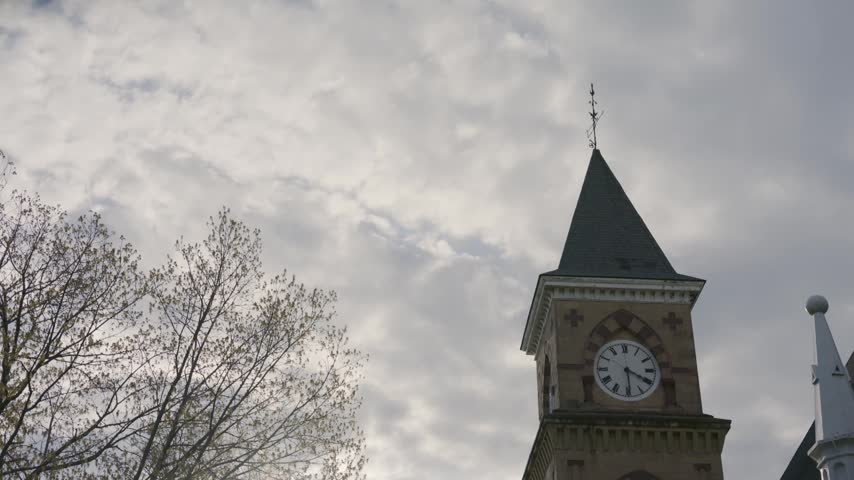 Cinematic gimbal tilt down shot of Music Hall clock at University of Wisconsin during sunrise with warm natural light.