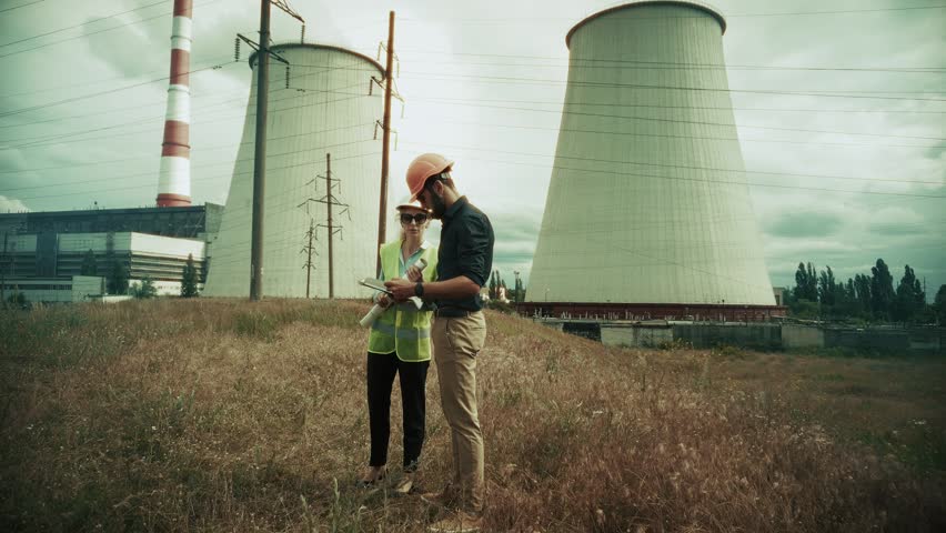 Engineer Power Plant. Engineer Power Plant Industry, Energy Station Architecture Development. technical documentation review session. Every Engineer Needs Precise Planning. Engineer Power Plant Industrial Landscape Growth Work. Successful Construction Milestone Together. Urban Infrastructure Management Routine. Modern Building Process Coordination. Workers Helmet Safety Vest Technical Inspection. Professional Engineering Task Activity. Cooling Towers Background