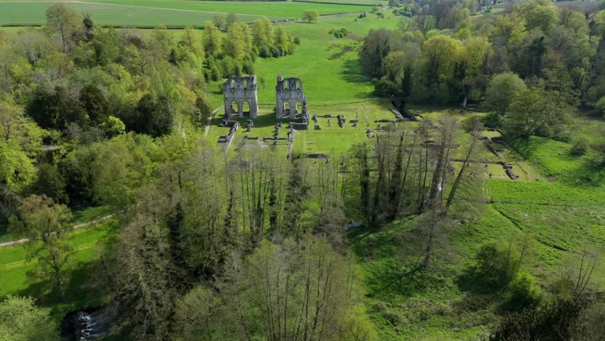 Aerial view of the historic ruins of Roche Abbey surrounded by lush green trees and rolling meadows in Maltby, England, United Kingdom.