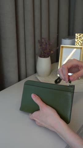 Close up of female hands taking euro cash from wallet indoors. Concept of personal finance, budgeting, household expenses, saving money and everyday payments.