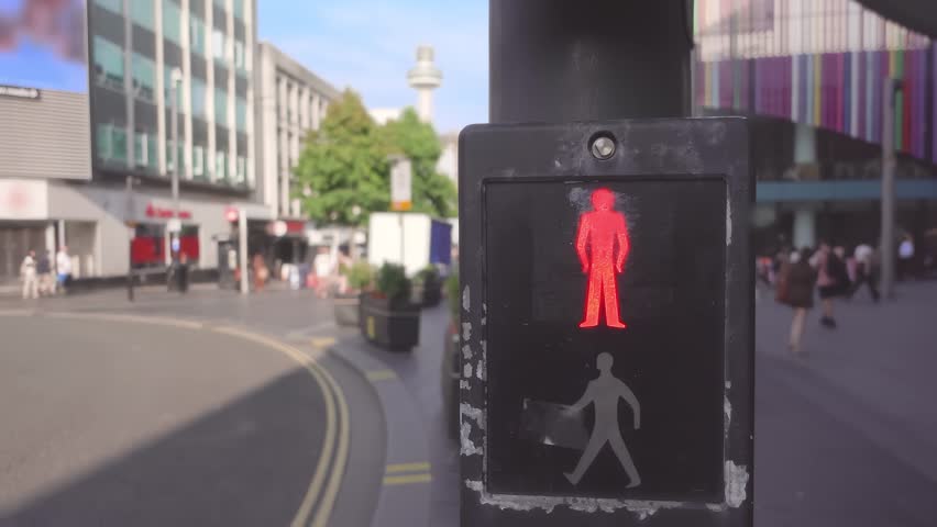A pedestrian traffic light glowing red on a street in Liverpool. Urban crossing city scene.