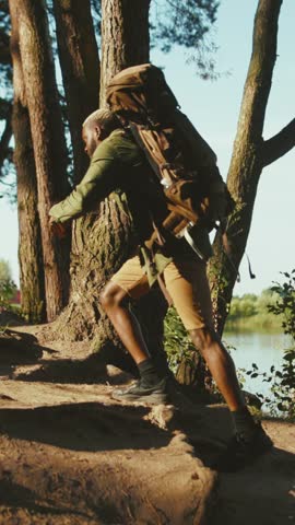 An Adventurous Hiker is Climbing Up a Mountain Trail Near a Serene and Beautiful Lake