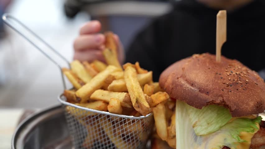 Fresh gourmet burger served with crispy fries in modern restaurant setting