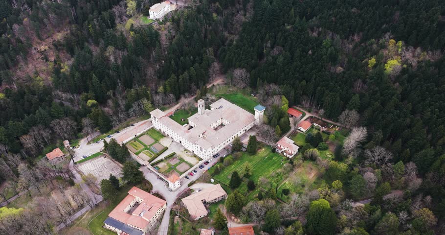 Aerial view of the historic Vallombrosa Abbey complex with its bell tower and formal gardens surrounded by dense forest in Vallombrosa, Tuscany, Italy.