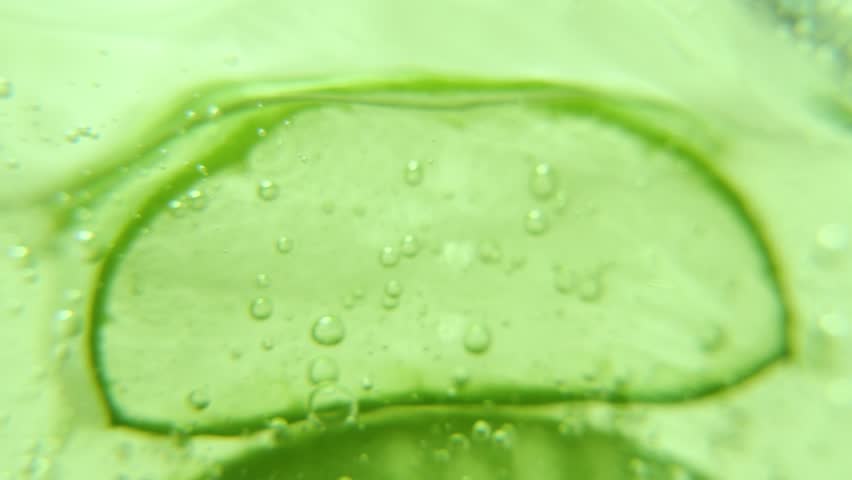 Serum gel texture with aloe vera leaf and bubbles, transparent cream background