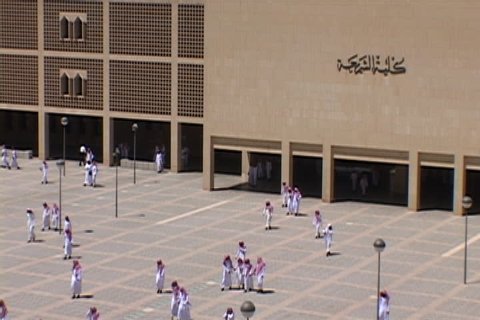 RIYADH, SAUDI ARABIA - OCTOBER 01, 2002: Overhead view of university courtyard. Many men dressed in white, with red and white checked keffiyeh, walk across courtyard.