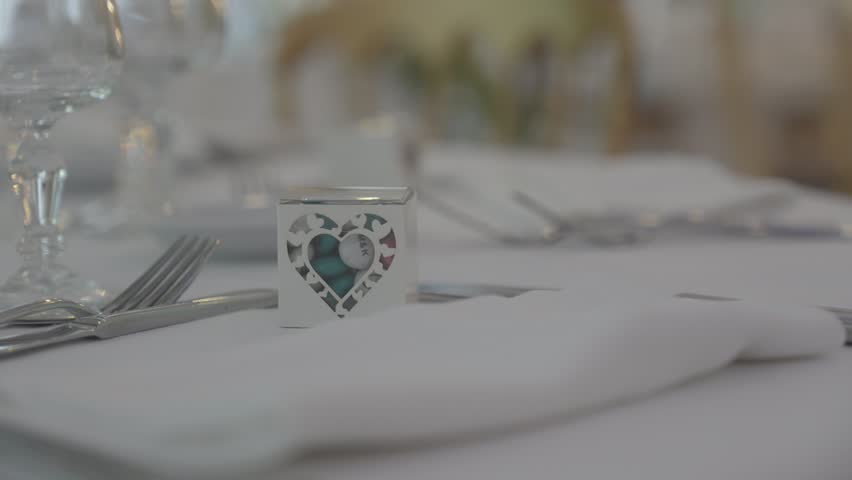 Heart shaped wedding favor box on table setting at the reception area, subject tracking shot closeup