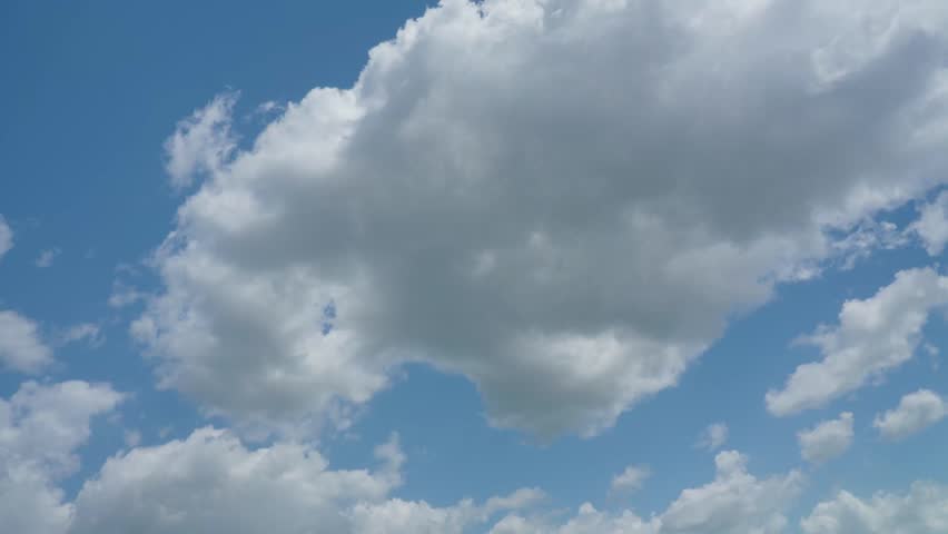 Large fluffy white cloud moving in blue sky
