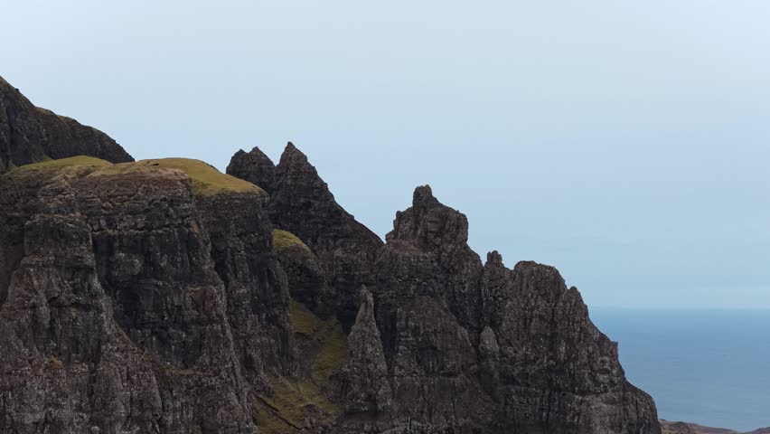 Aerial view moving downwards along the rugged and dramatic basalt rock formations of the quiraing on the isle of skye in scotland